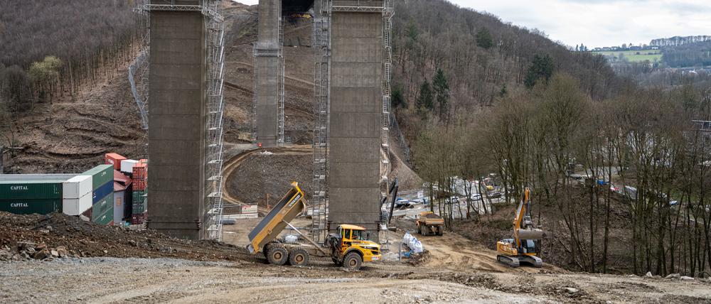 Arbeiter und Baustellenfahrzeuge unter der Rahmede-Talbrücke der Autobahn 45.