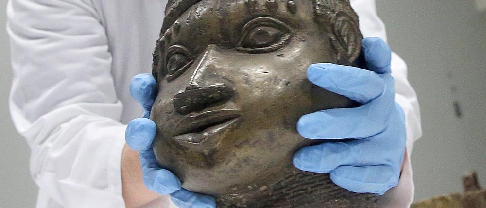 Eine Museumsmitarbeiterin verpackt eine der Benin-Bronzen, die für die Rückgabe nach Nigeria im Ethnologischen Museum Dahlem zusammen gestellt wurden. 
