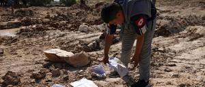 Ein palästinensischer Junge hebt Papiere und Bücher vom Gelände einer Schule auf, die von den israelischen Behörden abgerissen wurde, weil sie angeblich ohne Genehmigung gebaut worden war.