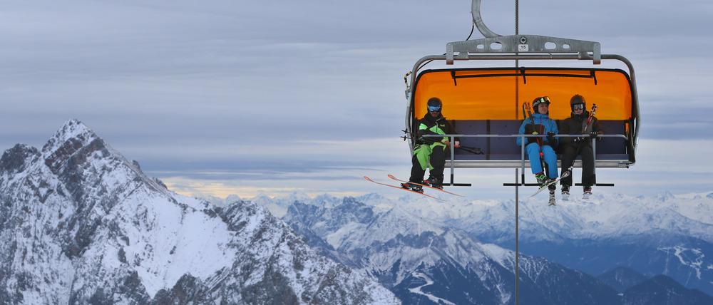 Wintersportler an der Zugspitze in einem Sessellift (Symbolbild)
