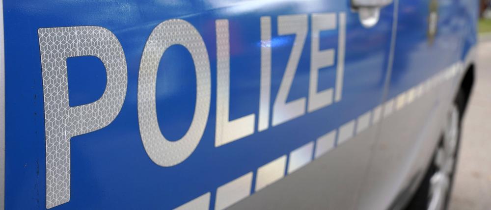 Schriftzug der Polizei an Polizeifahrzeug.