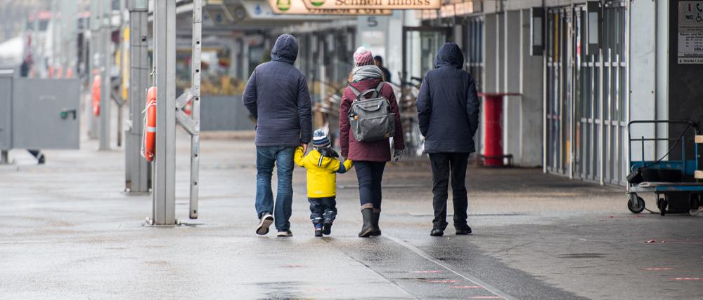 Eine Familie geht durch eine leere Stadt (Archivbild). 