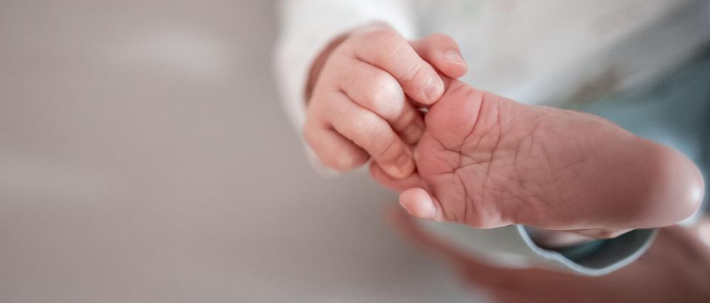 ARCHIV - 30.12.2019, Nordrhein-Westfalen, Oberhausen: Ein Baby greift mit den Fingern nach seinem Fuß. (zu dpa: Gesellschaft für deutsche Sprache gibt beliebteste Babynamen bekannt) Foto: Fabian Strauch/dpa +++ dpa-Bildfunk +++
