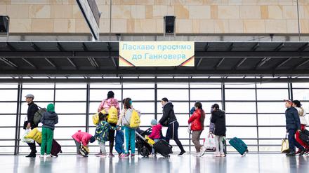 Geflüchtete aus der Ukraine laufen nach ihrer Ankunft durch die Eingangshalle vom Messebahnhof Laatzen.