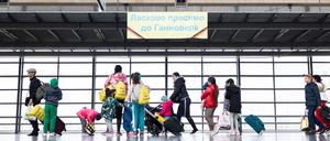 Geflüchtete aus der Ukraine laufen nach ihrer Ankunft durch die Eingangshalle vom Messebahnhof Laatzen.