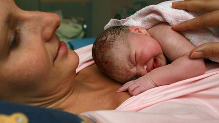 Im Kreißsaal des Klinikums in Frankfurt (Oder) liegt ein neugeborenes Baby ganz dicht bei seiner Mama.