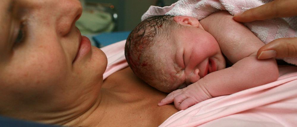 Im Kreißsaal des Klinikums in Frankfurt (Oder) liegt ein neugeborenes Baby ganz dicht bei seiner Mama.
