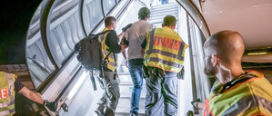 Polizeibeamte begleiten einen Menschen, der per Flugzeug in sein Heimatland zurückgebracht wird. 