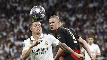 Toni Kroos (l.) zeigt sich zufrieden mit dem Unentschieden gegen Manchester City und Stürmerstar Erling Haaland.