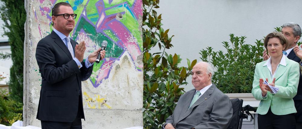 „Kanzler der Einheit“. Der ehemalige Bundeskanzler Helmut Kohl (Mitte), „Bild“-Chefredakteur Kai Diekmann und Maike Kohl-Richter enthüllen 2011 ein Stück der früheren Berliner Mauer, die in Kohls Garten platziert werden soll. Kai Diekmann war mit Helmut Kohl in tiefer Freundschaft verbunden.