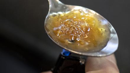 Über der Flamme eines Feuerzeuges kocht ein Drogensüchtiger in einem Druckraum eine Portion Heroin in einem Löffel auf, um sich die Droge anschließend zu spritzen. 