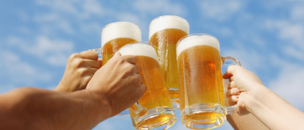 Bierkrüge beim Anstoßen.