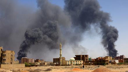 FILE PHOTO: A man walks while smoke rises above buildings after aerial bombardment, during clashes between the paramilitary Rapid Support Forces and the army in Khartoum North, Sudan, May 1, 2023. REUTERS/Mohamed Nureldin Abdallah/File Photo