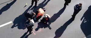 Aktivisten werden von Polizisten von der Stadtautobahn gelöst.