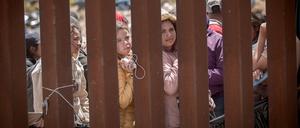 Frauen stehen hinter der Grenzmauer zwischen Mexiko und USA und hoffen darauf, in die USA einreisen zu können.