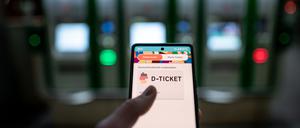 Ein Mann hält ein Mobiltelefon, auf dem das ·D-Ticket· gekauft werden kann, vor Ticketautomaten am Hauptbahnhof Essen in der Hand. (Symbolbild).