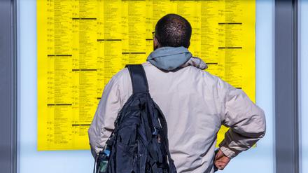 Ein Reisender liest während des Warnstreiks der EVG den Fahrplan mit den Abfahrtszeiten der Zügen auf einem Bahnsteig auf dem Hauptbahnhof. 