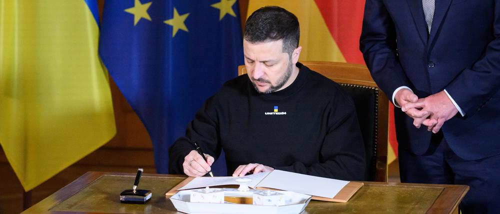 Wolodymyr Selenskyj, Präsident der Ukraine, trägt sich vor seinem Gespräch mit Bundespräsident Frank-Walter Steinmeier in das Gästebuch im Schloss Bellevue ein.