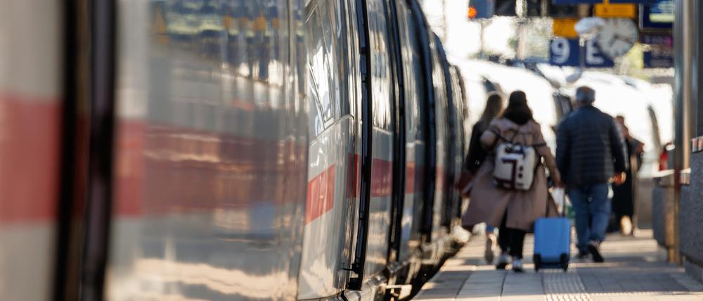 Archivbild: Reisende gehen mit Gepäck am Bahnsteig am Nürnberger Hauptbahnhof neben einem ICE entlang.