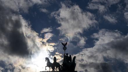 Die Quadriga auf dem Brandenburger Tor zeichnet sich im Gegenlicht der tief stehenden Sonne ab. 