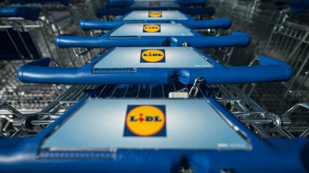 Einkaufswagen stehen vor einer Filiale des Lebensmitteldiscounters Lidl (Symbolbild).
