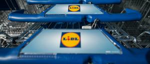 Einkaufswagen stehen vor einer Filiale des Lebensmitteldiscounters Lidl.