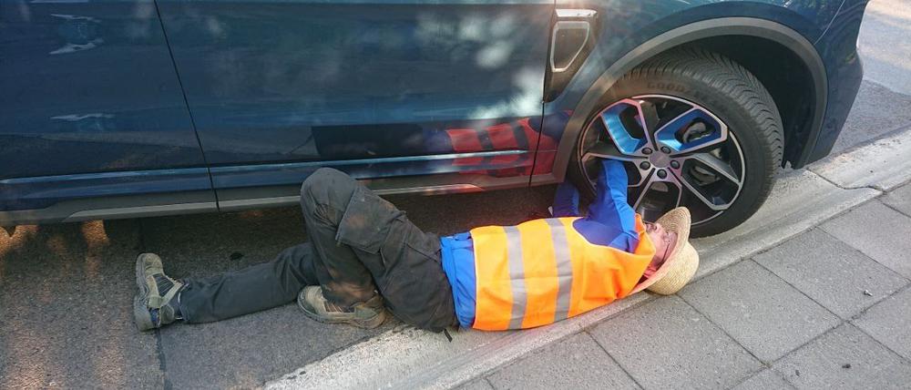 Ein Aktivist hat sich an einem Autoreifen festgeklebt.