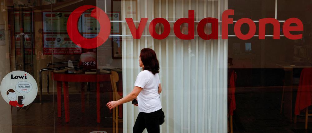 Eine Frau läuft an einem Geschäft von Vodafone vorbei.