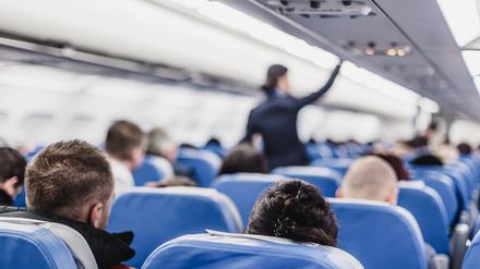 Eine Flugbegleiterin im Gang eines Flugzeugs.