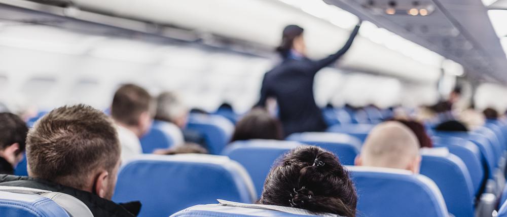 Eine Flugbegleiterin im Gang eines Flugzeugs.