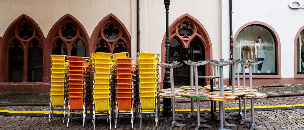 Gestapelte Tische und Stühle eines Eiscafés in Freiburg.