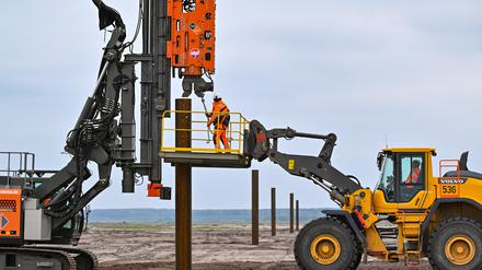 Sogenannte Dalben, Stahlrohre als Befestigungspunkt, werden beim Bau einer schwimmenden Photovoltaik-Anlage in die Erde auf dem Gelände des künftigen Ostsees gerammt.