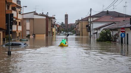 Ein Bürger fährt am 16. Mai in Cesena mit einem aufblasbaren Kajak zwischen den überschwemmten Häusern hin und her, um einige im Haus festsitzende Personen an Land zu bringen.