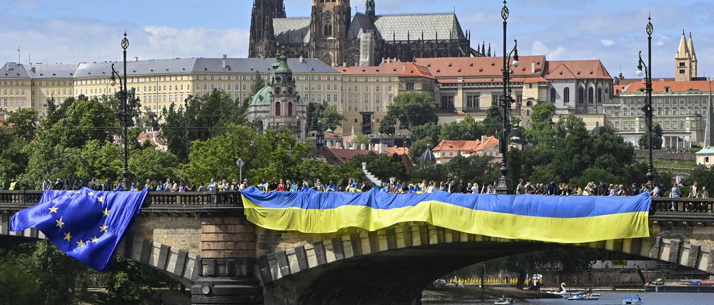 Auf einer Brücke in Prag hängt die ukrainische Flagge als Zeichen der Solidarität (Archivbild).
