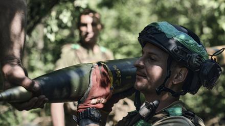 Ein ukrainischer Soldat trägt eine Rakete für ein Grad-Mehrfachraketenwerfersystem, um auf russische Stellungen an der Frontlinie in der Nähe von Bachmut zu feuern.