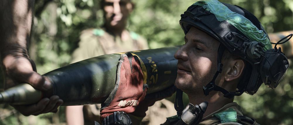 Ein ukrainischer Soldat trägt eine Rakete für ein Grad-Mehrfachraketenwerfersystem, um auf russische Stellungen an der Frontlinie in der Nähe von Bachmut zu feuern.