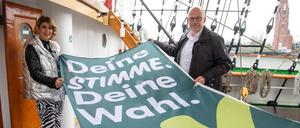 Sülmez Colak, bisher Vizepräsidentin der Bremischen Bürgerschaft, und Torsten von Haaren (SPD), Stadtverordnetenvorsteher Bremerhaven, halten eine Flagge mit der Aufschrift „Deine Stimme, deine Wahl“ auf dem Schulschiff Deutschland.
