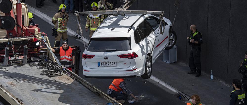 Ein Abschleppwagen transportiert auf der Autobahn 100 einen Wagen ab, unter dem sich ein Aktivist der Gruppe Letzte Generation auf die Fahrbahn geklebt hatte. 