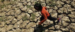 Philippinen, Molino: Ein Kind läuft in einem Bewässerungskanal, der durch das Klimaphänomen „El Nino“ ausgetrocknet war.