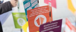 Eine Jugendliche steht an einem Wahlstand für die U-18-Wahl neben Zetteln mit Informationen zu den Parteien.