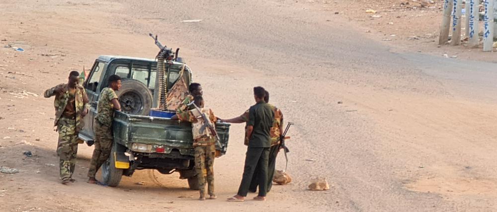 Soldaten der sudanesischen Armee stehen am 20. Mai 2023 neben ihrem Fahrzeug auf einer mit Ziegelsteinen blockierten Straße in Khartum.