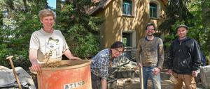 Kristina Gummlich (l) und Christian Bott (2.v.r) stehen zusammen mit den Helfern Agata Kopka und Jason Adkins am Lehmmischer auf der Baustelle für ihr neues Eigenheim. Ein auffälliges braunes Haus aus Lehm wächst im Bernauer Ortsteil Birkholzaue (Barnim) und zieht immer wieder Schaulustige an. 