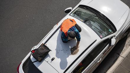Ein Aktivist der Gruppe Letzte Generation hat sich bei einer Blockade auf der Autobahn 100 auf einem Autodach festgeklebt.  
