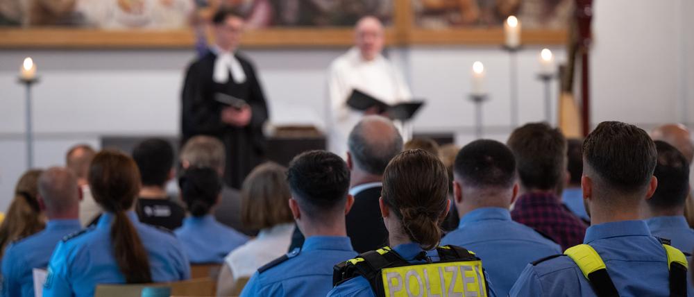 Polizistinnen und Polizisten sitzen in einem Gottesdienst in der Martin-Luther-Kirche.