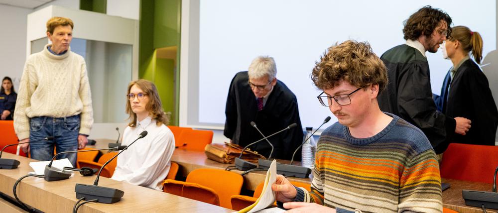 Die angeklagten Klimaaktivisten Michael Winter (l-r), Lukas Popp und Simon Lachner sitzen zum Prozessauftakt auf der Anklagebank.