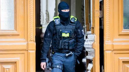Ein Polizist bei einer Hausdurchsuchung. (Symbolbild)