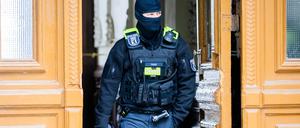 Ein Polizist bei einer Hausdurchsuchung. (Symbolbild)