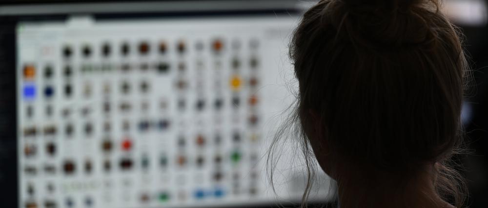 ARCHIV - 15.04.2021, Hessen, Gießen: Eine Kriminaloberkommissarin sitzt in einem Büro vor einem Auswertungscomputer auf der Suche nach Kinderpornografie und Fällen von sexuellem Missbrauch. (Illustration zu «Kinderfotos im Netz - wie Eltern ungewollt Pädokriminelle beliefern») Foto: Arne Dedert/dpa +++ dpa-Bildfunk +++