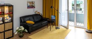 In der Pflege-Musterwohnung sind viele Assistenzsysteme für Seniorinnen und Senioren verbaut. Auf der Couch sitzt eine Pflege-Katze aus Plüsch.