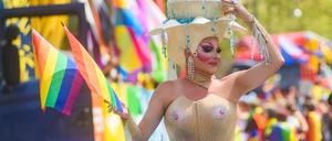 20. Mai 2023, Dessau, Sachsen-Anhalt: Eine Person in einem ausgefallenen Kostüm schwenkt bei der Parade zum Christopher Street Day eine Regenbogenflagge.